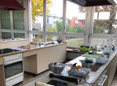 Zwei Kochzeilen mit Küchenutensilien und Fensterfront im Hintergrund
