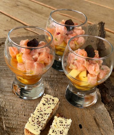 Kleine Gläser gefüllt mit Lachs- und Mangowürfel